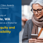 Announcement of the City of Seattle being selected for a Smart Cities Award showing a woman with gray hair looking at her phone