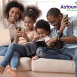 A family sitting together looking at laptops and phones.