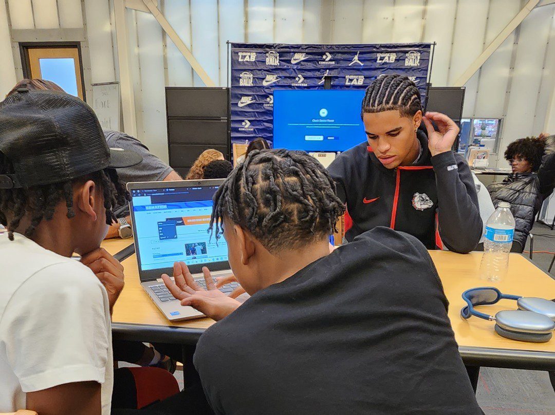 Three black youth working on computers in a classroom