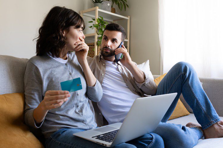Worried couple discovering that their credit card has been hacked