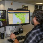 A man looking at a map of Seattle on his computer screen.
