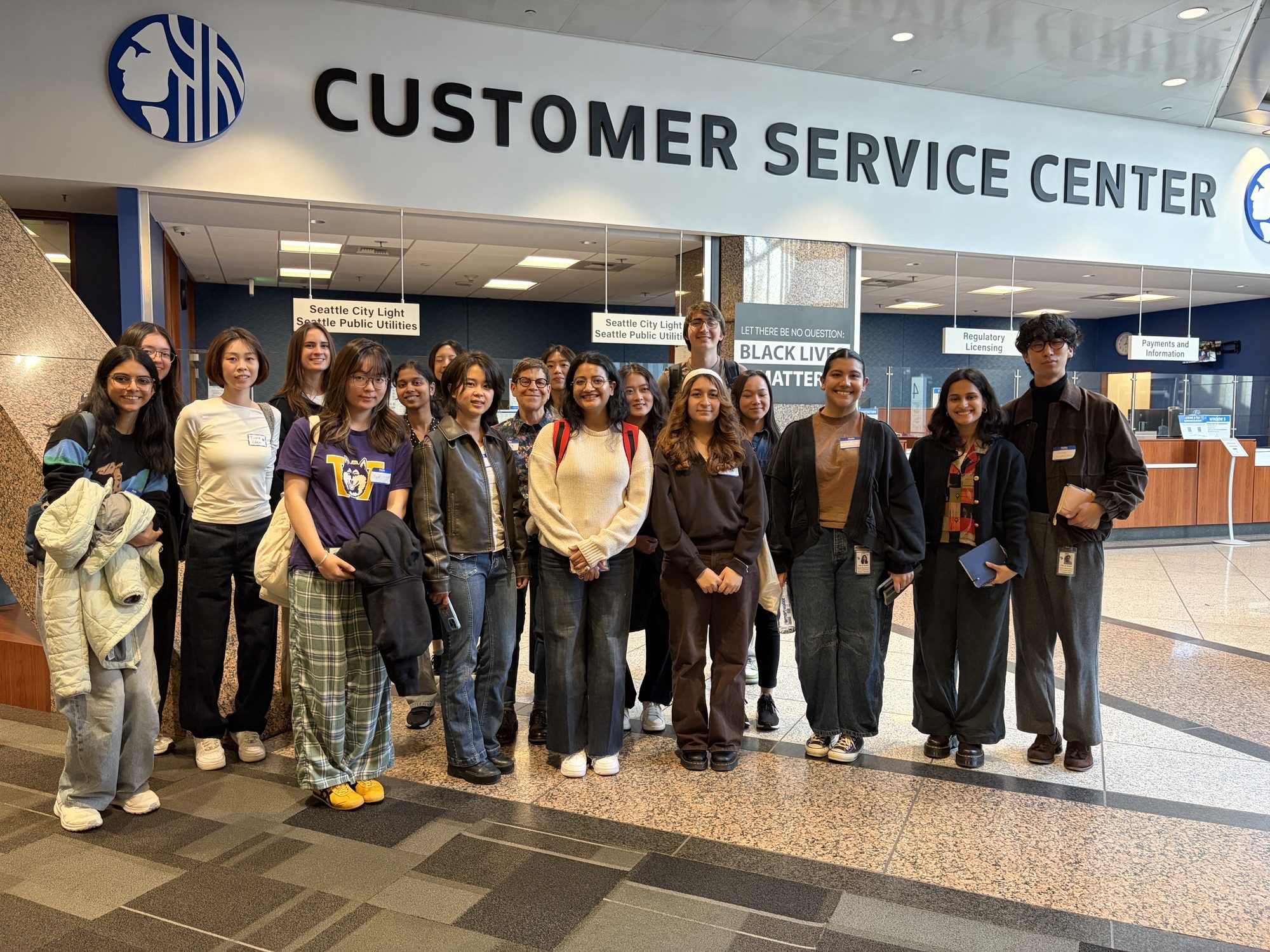 A group of students and Seattle city staff standing in front of the customer service center